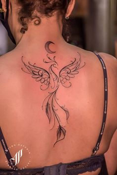 the back of a woman's neck with an intricate tattoo design on her left side