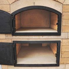 two open ovens sitting on top of a brick wall