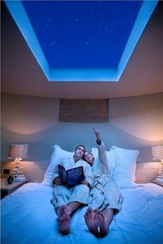 a woman laying in bed under a blue light