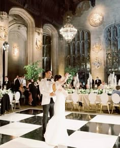 a bride and groom dance on the dance floor in front of their guests at an elegant wedding reception