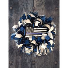 a patriotic wreath with an american flag and stars on the front, sitting on a wooden surface