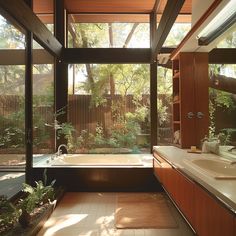 a bathroom with a tub, sink and large windows