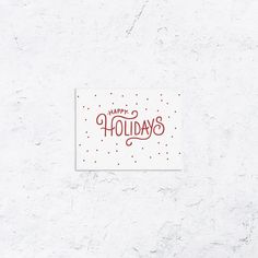 a red and white holiday card with the words happy holidays written in cursive writing