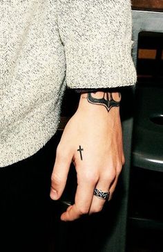 a person with a cross tattoo on their left hand and the words, magic hands