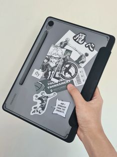 a person holding an ipad with stickers on it's back cover and pointing at the screen