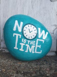 a rock with the words now is the time painted on it