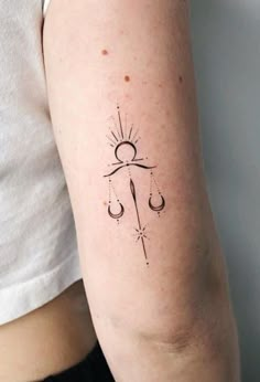 a woman's arm with a tattoo on it that has an anchor and hook