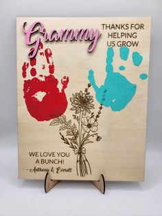 a wooden sign with handprints and flowers on it that says, thank for the helping us grow