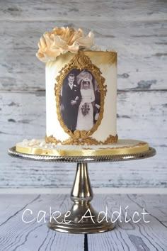 a white and gold wedding cake with an old photo on it