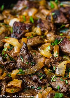 meat and onions cooking in a skillet with parsley on the top, ready to be eaten