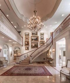 a large foyer with chandelier and paintings on the wall