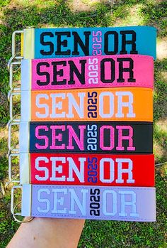 a person holding up a colorful book with the words senior on it in different languages