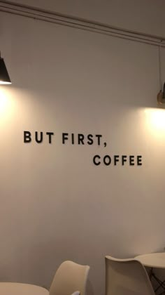 there is a sign that says but first, coffee on the wall next to two chairs