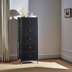 a tall black chest of drawers in a room