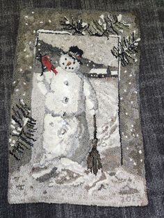 a rug with a snowman on it and pine trees in the backgroud