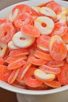 a bowl filled with sugar coated donuts on top of a table