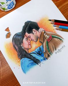 a drawing of a couple kissing on the cheek with colored pencils next to it