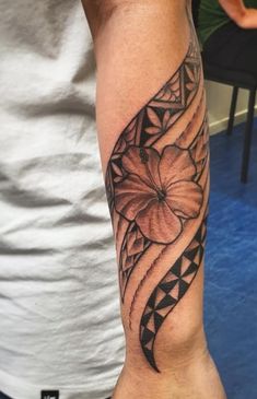 a man's arm with a flower tattoo on the left side of his arm