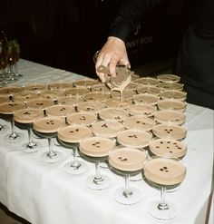 a table topped with lots of wine glasses filled with champagne and covered in wooden buttons