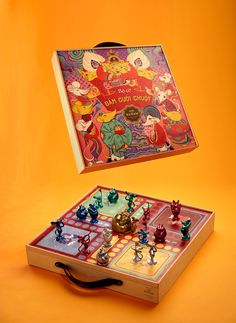 an old board game set up on top of a wooden box with the cover open