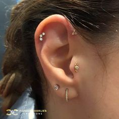 a woman with three different ear piercings on her left side, and one behind the ear