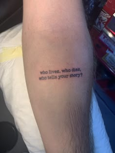 a person with a tattoo on their arm that says who lives, who tells your story?