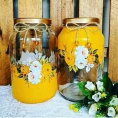 two yellow jars with flowers painted on them