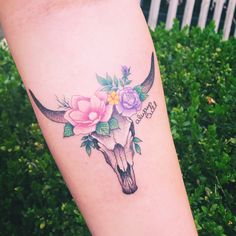 a cow skull with flowers on it's side