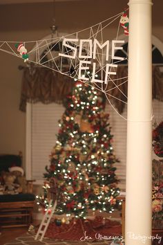 a decorated christmas tree in the corner of a living room with some lights on it