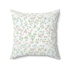 a white pillow with pink, blue and green floral print on it's side