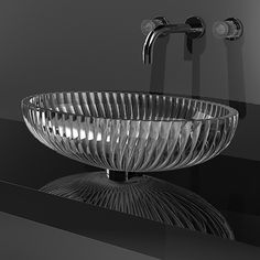 a glass bowl sitting on top of a counter next to a faucet sink