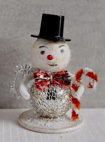 a snowman with a top hat holding a candy cane