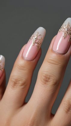 a woman's hand with some pink and white nail polishes on her nails