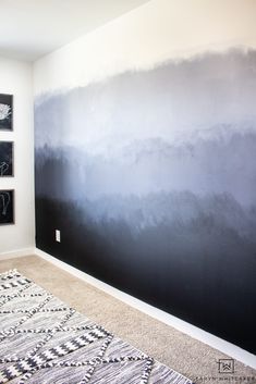 a room with black and white artwork on the wall next to a carpeted floor