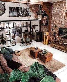 a living room filled with furniture and lots of plants on top of the rugs