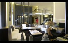 a living room filled with white furniture and lots of windows next to a stair case