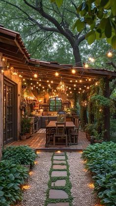 an outdoor dining area is lit up with string lights and greenery on the patio