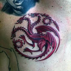 a man with a tattoo on his chest has a red dragon in the shape of a circle