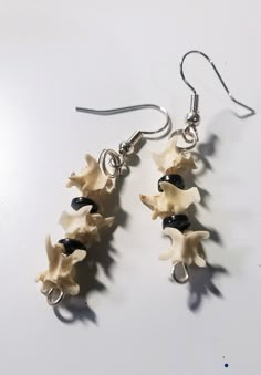 These spooky earrings are made from real rattlesnake vertebrae bones, and real hematite stone. Bones may have a natural patina. Hand set and finished, each piece is unique and perfect for your next spooky event, or just a conversation piece for daily wear. As these are real bones, they are small and delicate, so store and handle with care! Earrings are finished on a hypoallergenic ear wire. Bones were purchased from BackWoodBones on Etsy! Matching necklace available. Know your local state and co Spine Bone Jewelry, Animal Bone Jewelry Wire, Bone Crafts Earrings, Cuttle Bone Casting Jewelry, Animal Bone Jewelry Clay, Diy Bone Jewelry, Animal Bone Jewelry, Bone Accessories, Spooky Earrings