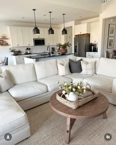 a living room filled with furniture and a kitchen in the background