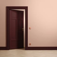 an open door in a room with pink walls and parquet flooring on the side