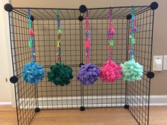 four balls of yarn are hanging in a cage