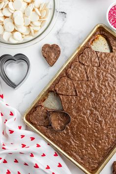 a baking pan filled with brownies and marshmallows on top of a table