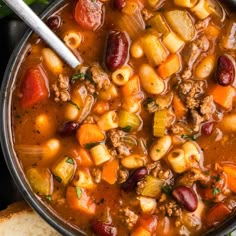 a pot filled with soup next to bread