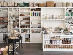 a store filled with lots of white shelves and baskets on top of it's walls