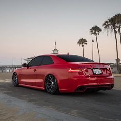 a red car is parked on the beach