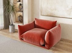 a living room with a red chair and potted plant