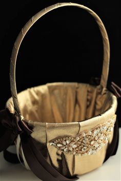 a basket that is sitting on top of a white table with a brown ribbon around it