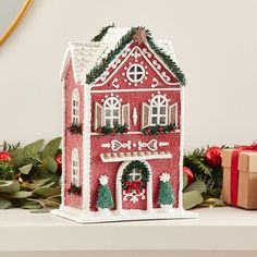 a red and white gingerbread house decorated for christmas