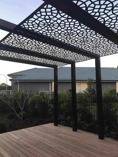 an outdoor patio with wooden decking and pergolated screens on the side of it